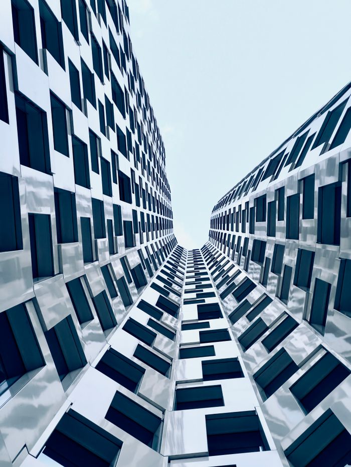 A captivating view of two modern buildings forming a symmetrical pattern against a clear sky.